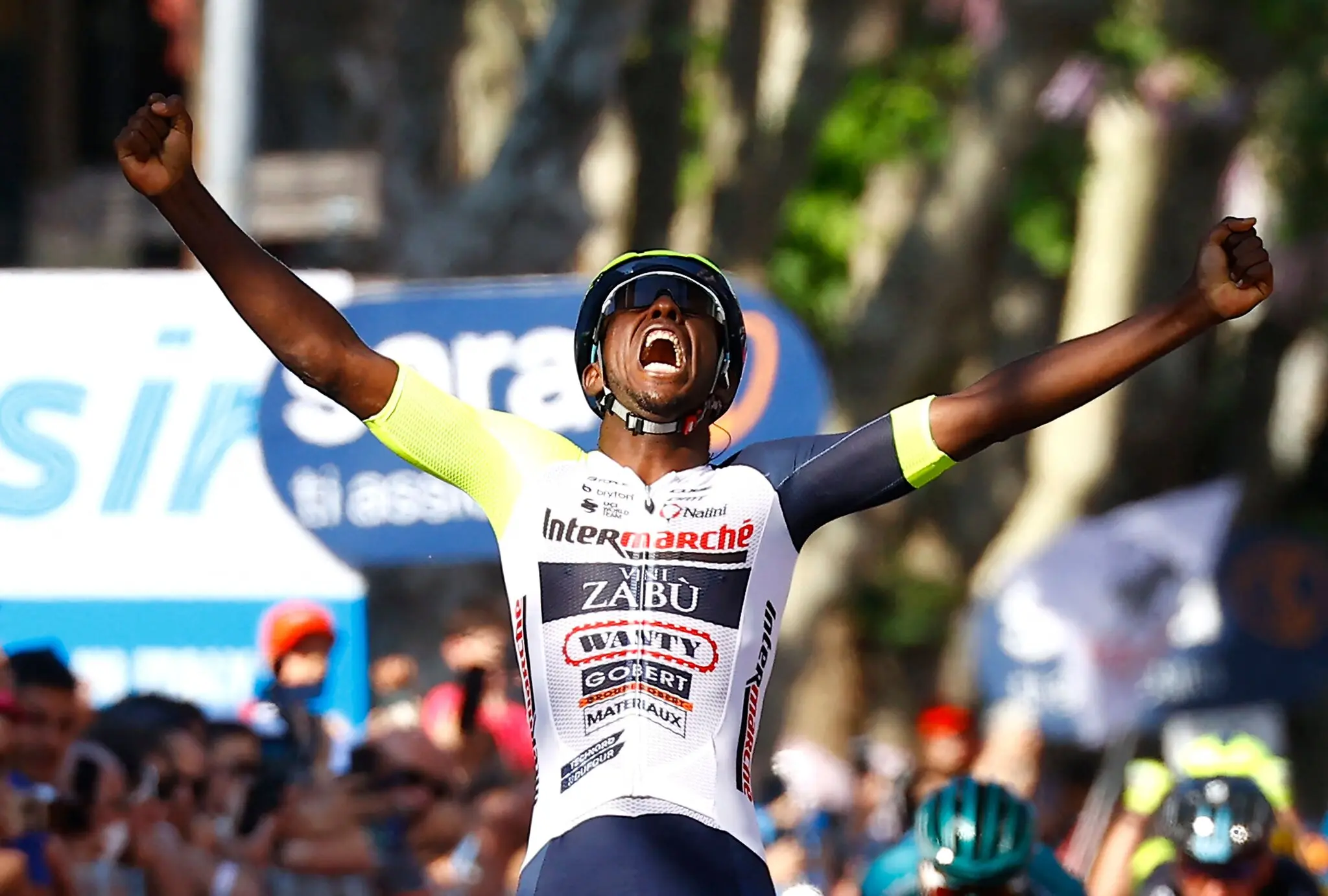 Cyclist celebrating at the finish line with arms raised